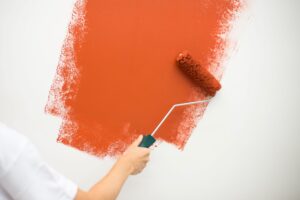 Izvajalec barva belo steno z oranžno barvo